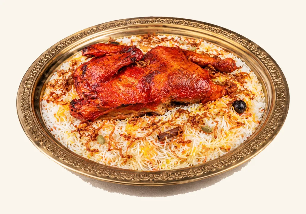 Tandoori-spiced roast chicken over Mandi rice on a brass platter